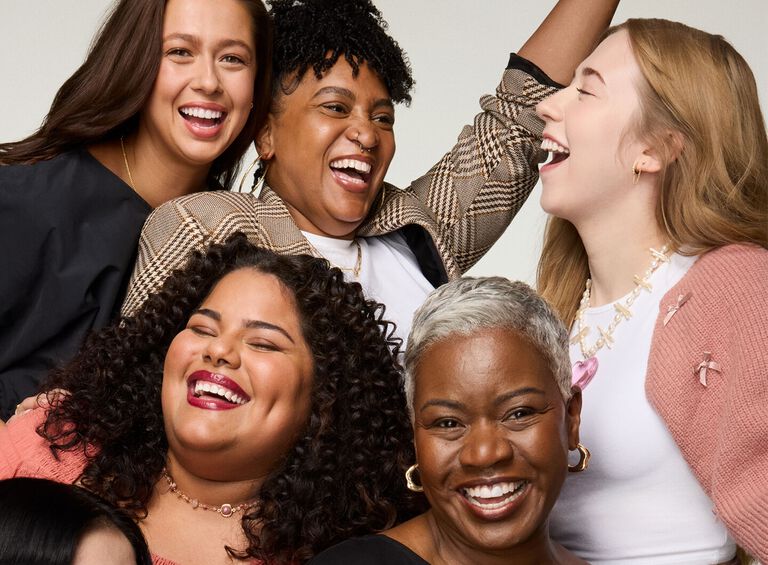 Group of diverse people wearing stylish outfits posing together against a neutral background.