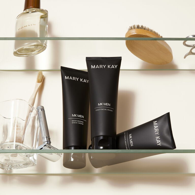 Mary Kay MKMen skincare products including shave cream, facial wash, and moisturizer displayed on a glass shelf with grooming accessories.